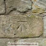 There is a worn Government Ordnance mark on the wall. Churches were considered to be good datum points and often marked. Not so far away is Ault Hucknall church which is similarly marked. Government Ordnance mark